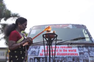A protester lights a ceremonial lamp at a rally organized by the Association of Relatives of the Enforced Disappeared in the North and East, held in Jaffna on 30 August 2026 as part of the “Long Road to Justice” conference marking the International Day of the Disappeared. Image courtesy of Kumara Kana.